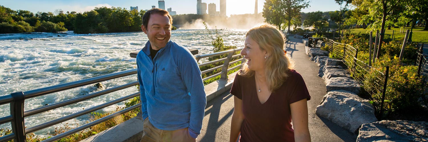 A happy couple hiking along a trail at Niagara Falls