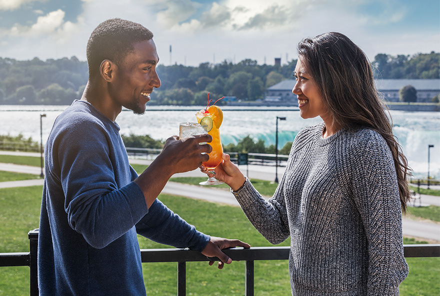 couple doing a toast with Niagara Falls in the background