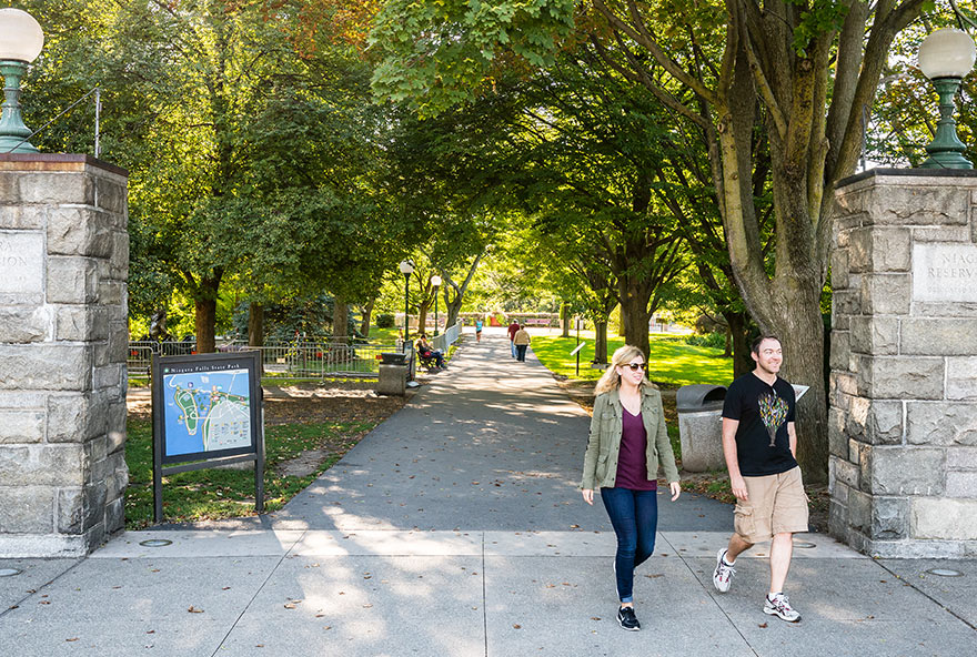 A couple walks on a paved path in Niagara Falls State Park