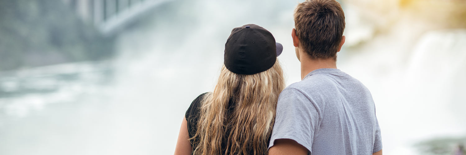 A couple gazes towards Niagara Falls at sunset
