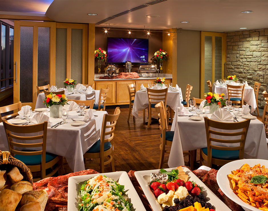 A restaurant dining room is set up with tables and food buffets