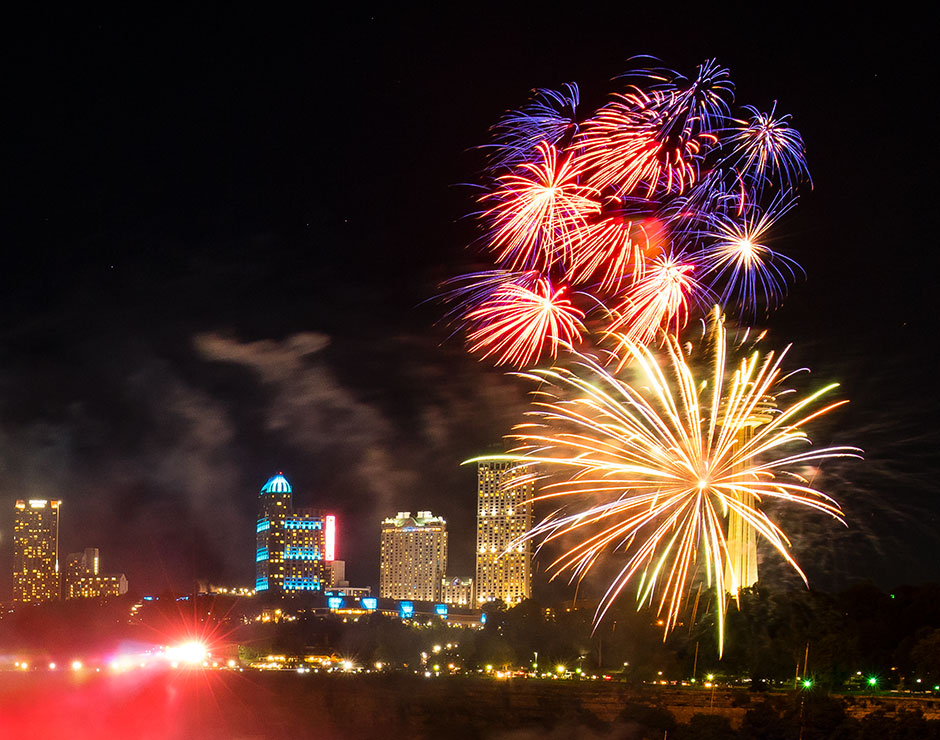 Fireworks at night above Niagara Falls light up the sky